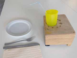 Neuentwicklung eines Becherhalters; a) bisheriger Becherhalter aus Holz (unflexibel und nicht hygienisch zu reinigen);