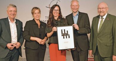 Jürgen Kroos, Präsident der HWK Münster, Ministerin Mona Neubaur (v. l.) und WHKT-Präsident Berthold Schröder (r.) nehmen die diesjährigen Ehrenamts-Preisträger, Nadine und Bernd Winkels, in ihre Mitte.